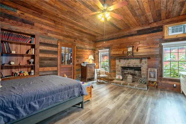 a bedroom with a bed a fireplace and a chandelier