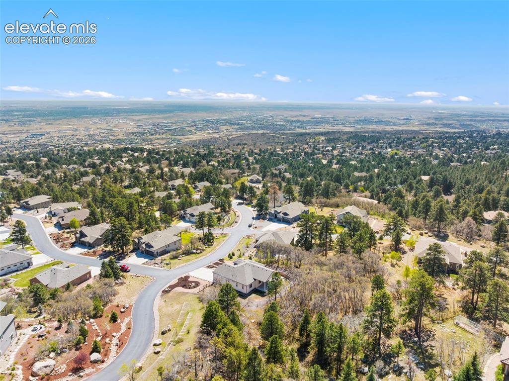 5375 Old Star Ranch View Colorado Springs, CO 80906 - Photo 5 of 47 Aerial perspective of a residential neighborhood with a vast distant cityscape under a clear sky