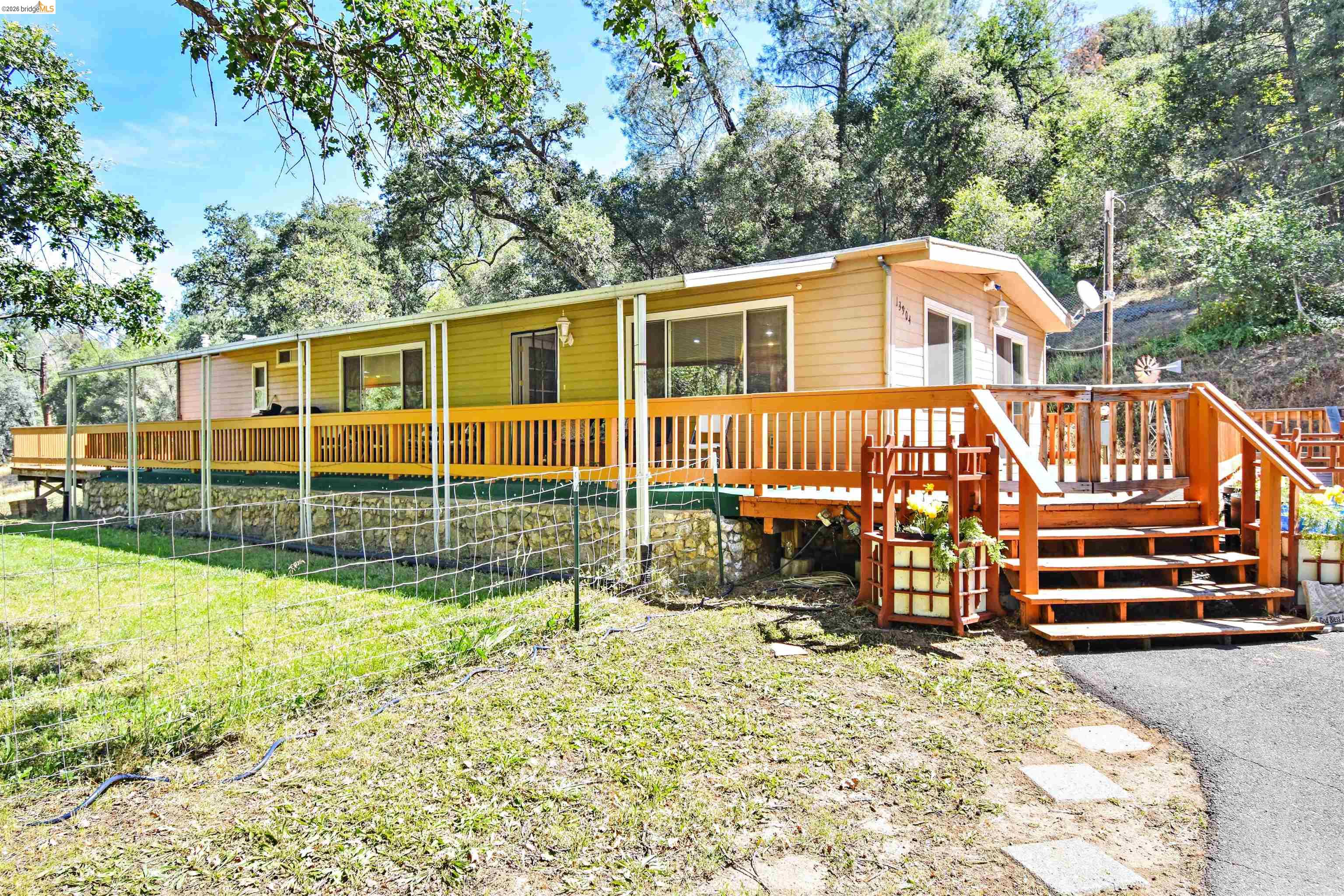 13904 Tuolumne Road Sonora, CA 95370 - Photo 44 of 44 Exterior residence featuring a full-length wooden deck with wood railings, steps, and an integrated gate