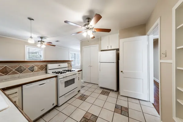 a kitchen with cabinets stainless steel appliances and a chandelier