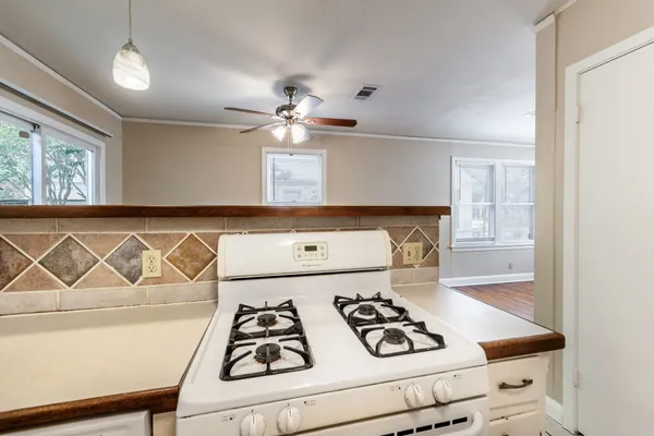 a white kitchen with a stove and a refrigerator