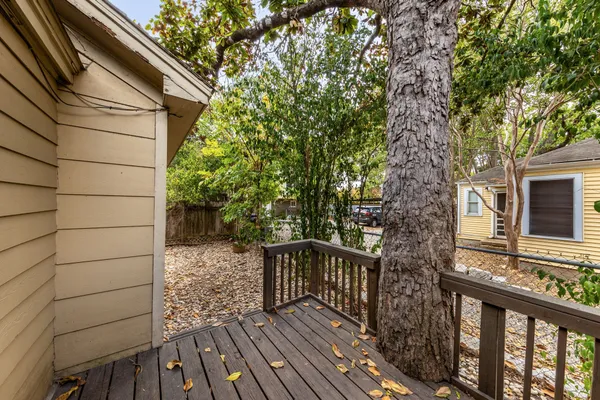a view of balcony with wooden floor and fence and a bench