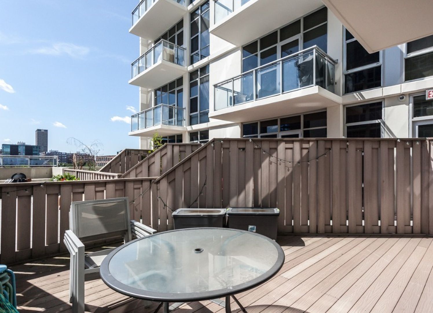 901 West Madison Street, Unit 404 Chicago, IL 60607 - Photo 12 of 12 a view of a patio with table and chairs with wooden floor and fence