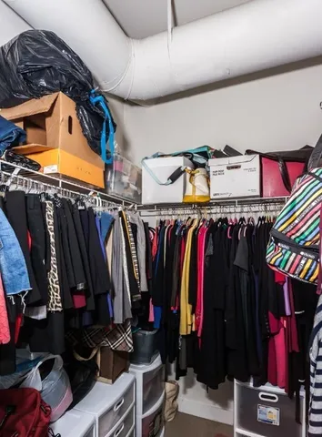 a view of walk in closet with clothes and shoes