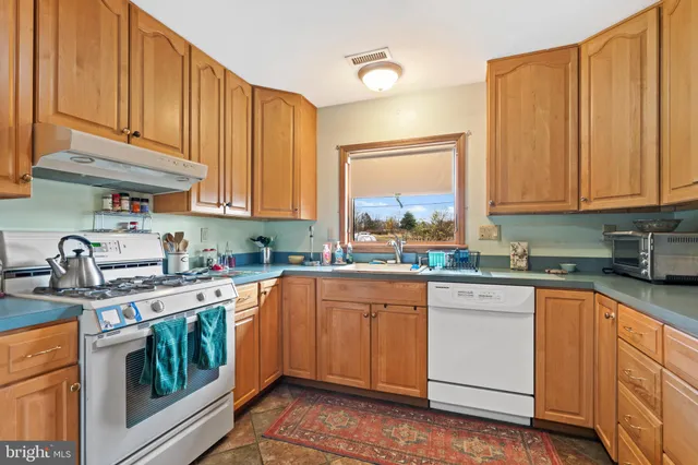 a kitchen with stainless steel appliances granite countertop a stove sink and cabinets