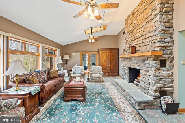 a living room with furniture a fireplace and a chandelier