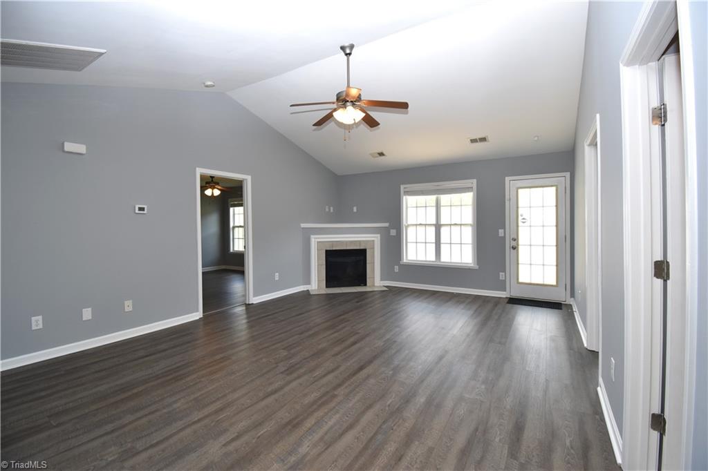 3910 Ribbon Grass Terrace Greensboro, NC 27405 - Photo 3 of 24 Wow what a great living room. Vaulted Ceiling with fan and gas log fireplace.