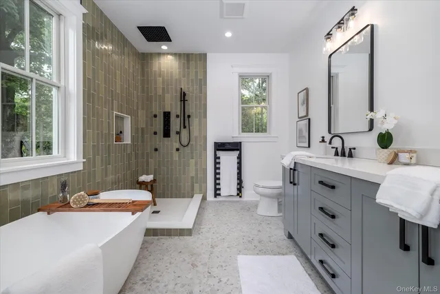 a bathroom with a double vanity sink a toilet a shower and a mirror