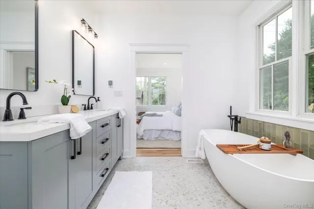 a spacious bathroom with sinks mirror and bathtub