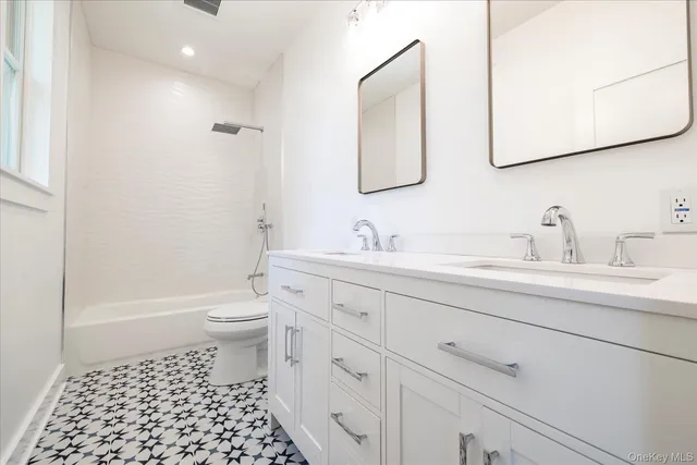 a bathroom with a sink a toilet and a mirror