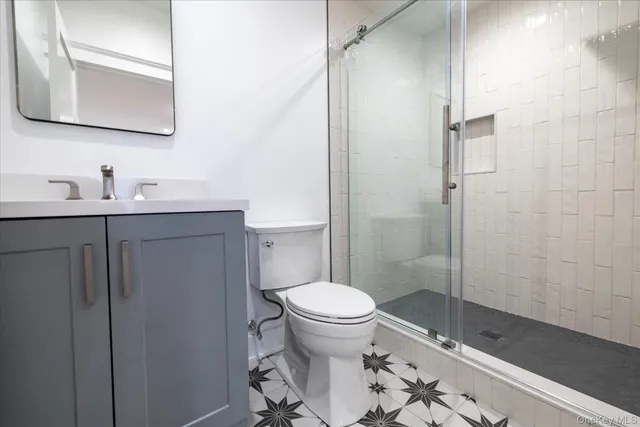 a bathroom with a granite countertop sink toilet and shower