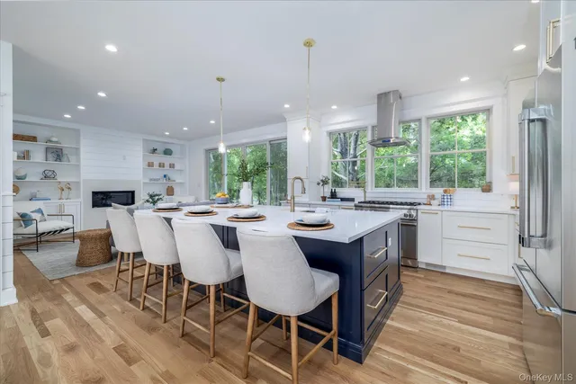 a kitchen with a dining table chairs and wooden floor