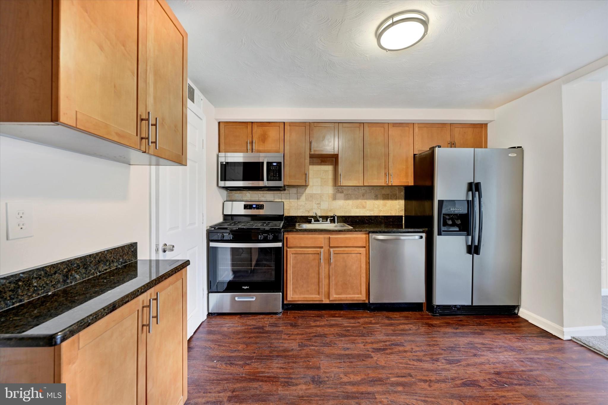 4436 Annapolis Road Halethorpe, MD 21227 - Photo 12 of 30 a kitchen with granite countertop a refrigerator stove and microwave