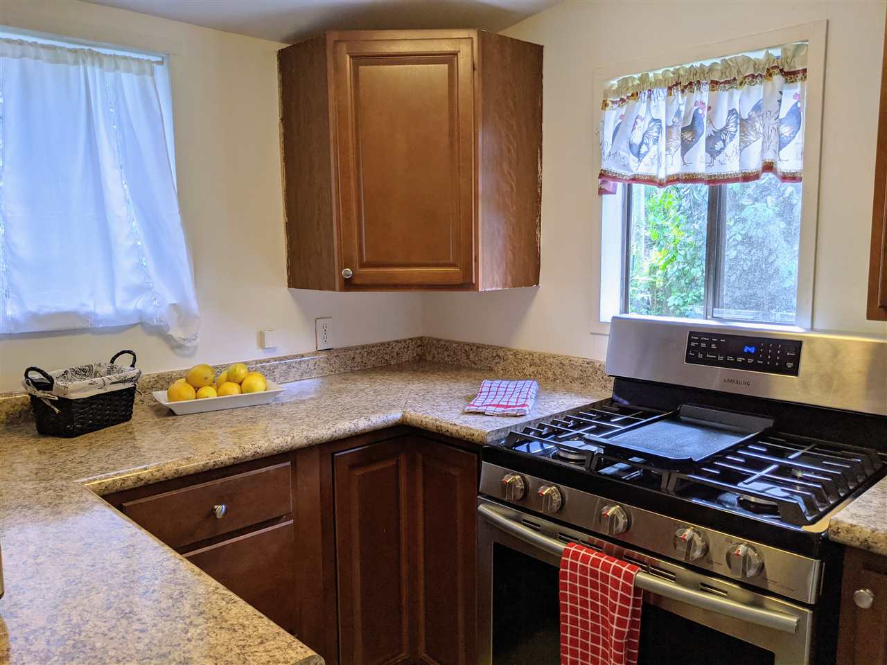 307 West Kuiaha Road Haiku, HI 96708 - Photo 11 of 30 a kitchen with a stove a cabinets and a window