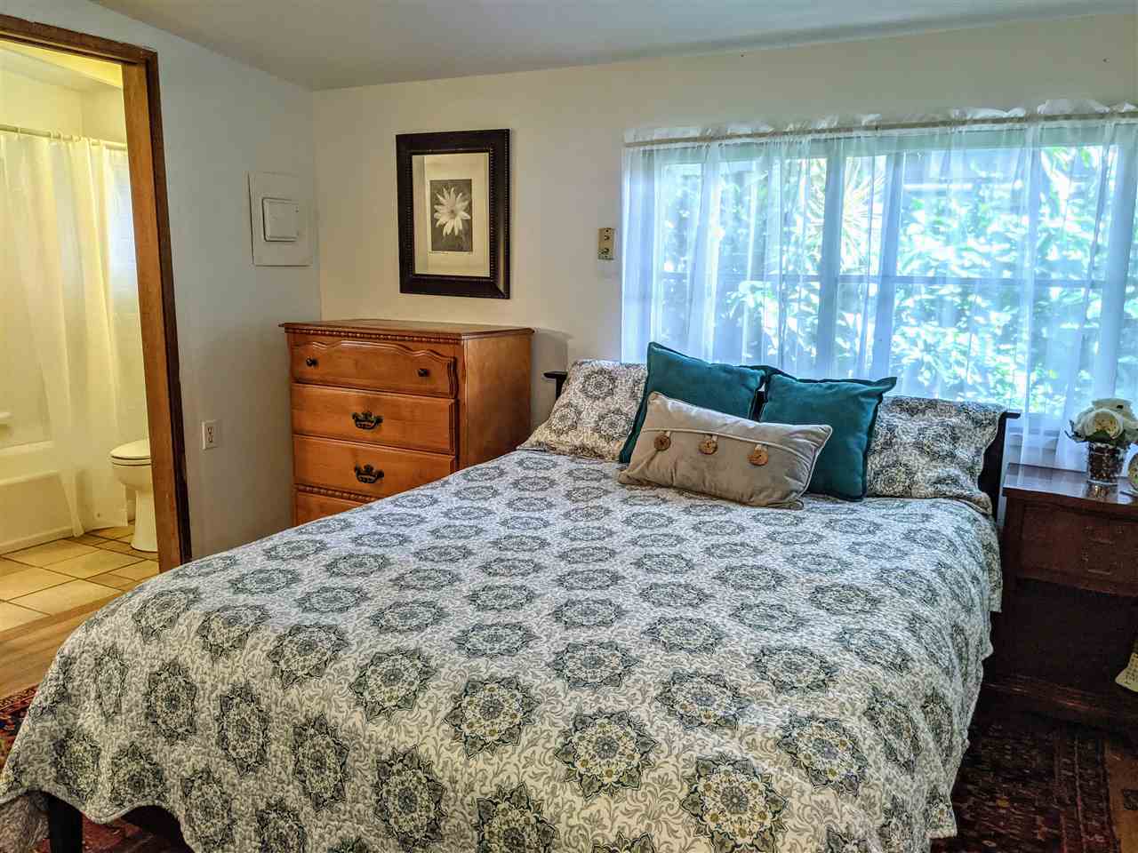 307 West Kuiaha Road Haiku, HI 96708 - Photo 12 of 30 a bedroom with a bed and wooden floor