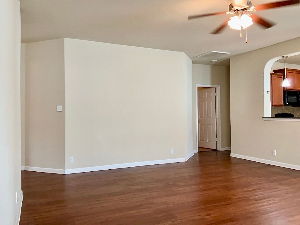 720 Noatak Trail Pflugerville, TX 78660 - Photo 4 of 20 a view of an empty room with wooden floor and a ceiling fan