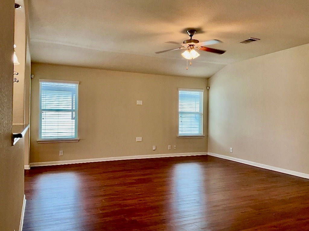 720 Noatak Trail Pflugerville, TX 78660 - Photo 6 of 20 an empty room with wooden floor chandelier fan and windows