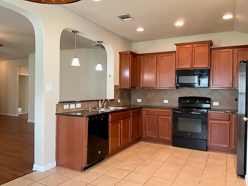 720 Noatak Trail Pflugerville, TX 78660 - Photo 7 of 20 a kitchen with stainless steel appliances granite countertop a refrigerator and a stove top oven