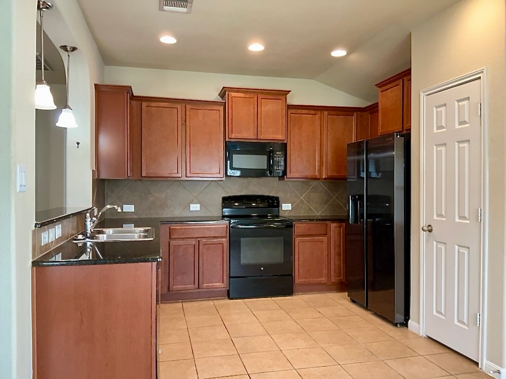 720 Noatak Trail Pflugerville, TX 78660 - Photo 8 of 20 a kitchen with stainless steel appliances granite countertop a refrigerator stove and sink
