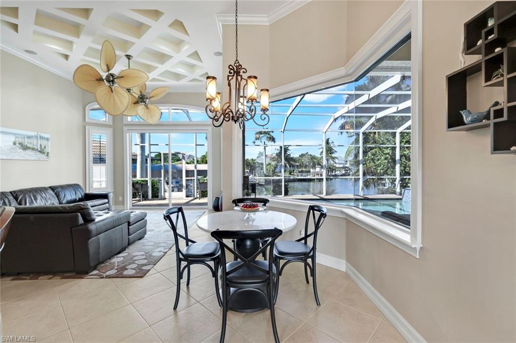 309 Rookery Court Marco Island, FL 34145 - Photo 8 of 49 a view of a dining room with furniture wooden floor and chandelier