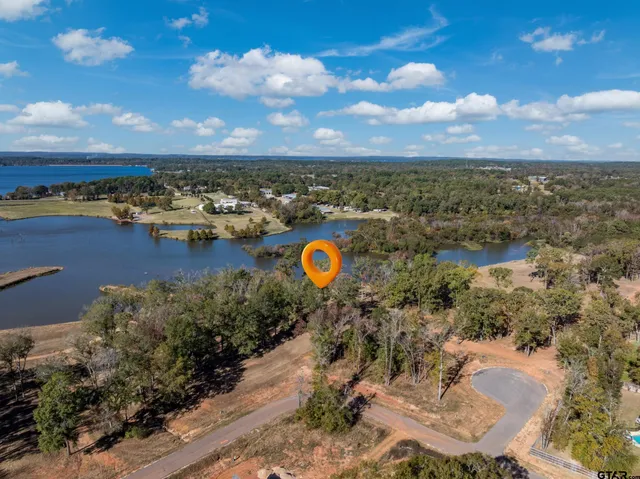 an aerial view of a house with a yard and lake view