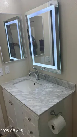 a bathroom with a granite countertop sink and mirror