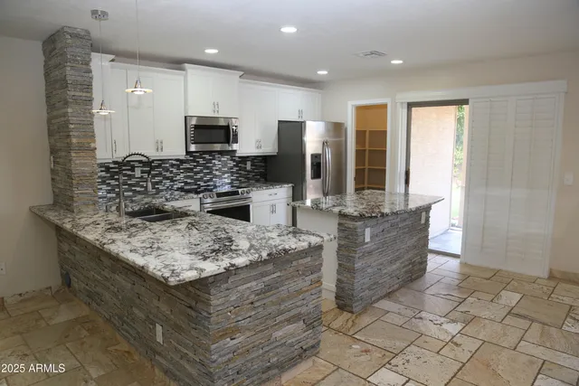 a kitchen with stainless steel appliances kitchen island granite countertop a large counter top and stove
