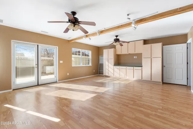 a view of empty room with wooden floor and windows