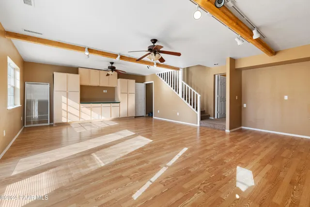 a view of a hall with wooden floor and stairs