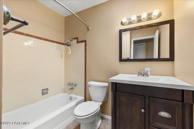 a bathroom with a toilet a sink a mirror a bathtub and shower