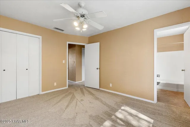 a view of a big room with wooden floor and ceiling fan