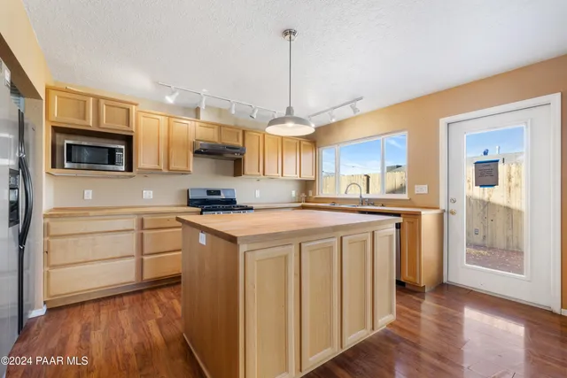 a kitchen with stainless steel appliances granite countertop a stove a sink and a refrigerator