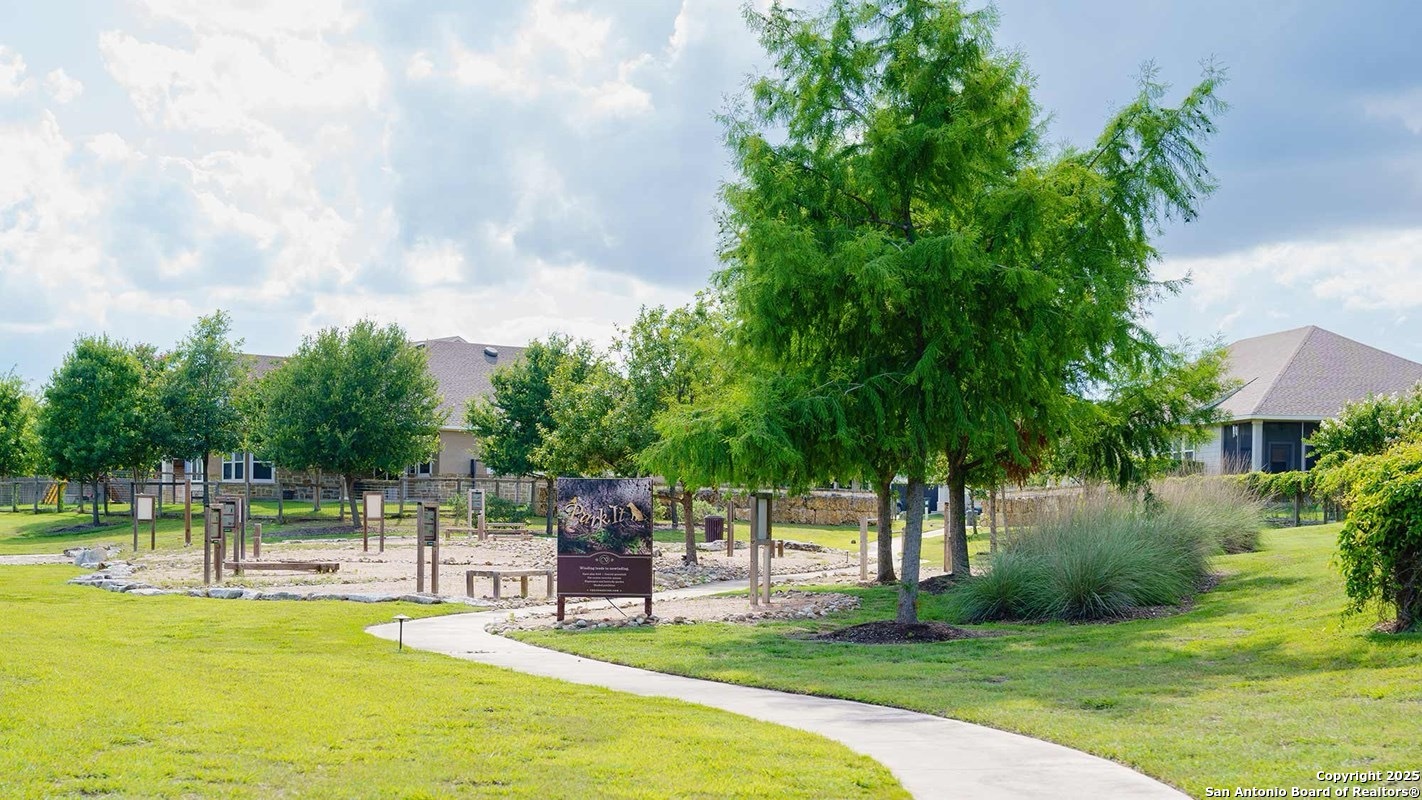 12110 Secret Vine Schertz, TX 78154 - Photo 6 of 7 a view of a swimming pool with a garden and trees