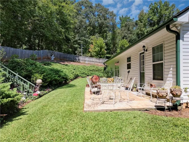 a view of house with backyard and outdoor seating