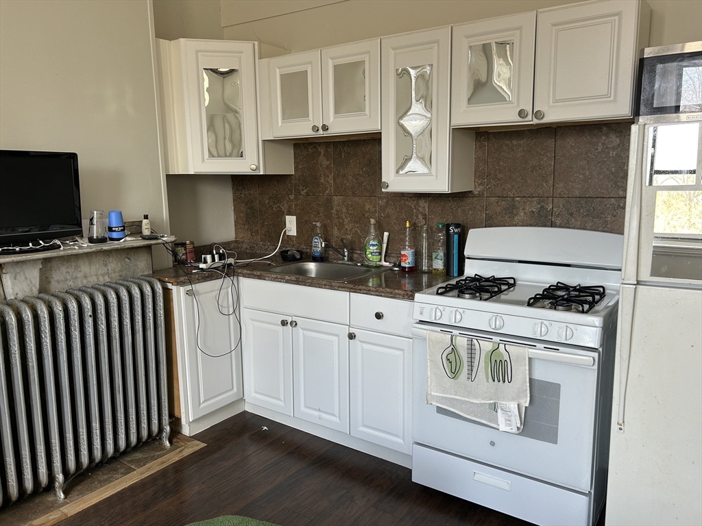 14 Monument Square, Unit 26 Boston, MA 02129 - Photo 2 of 7 a kitchen with stainless steel appliances granite countertop a stove a sink and white cabinets