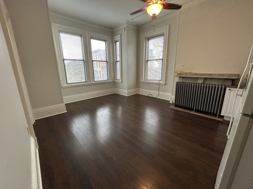 14 Monument Square, Unit 26 Boston, MA 02129 - Photo 3 of 7 an empty room with wooden floor and windows