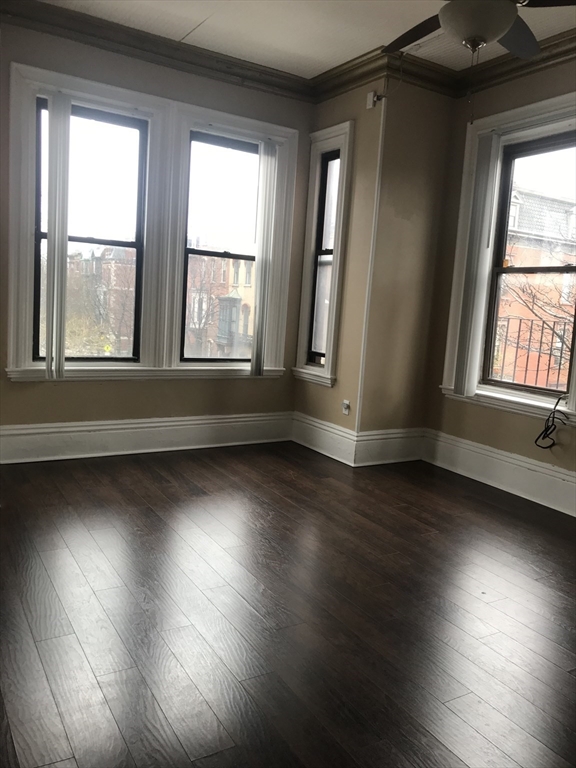14 Monument Square, Unit 26 Boston, MA 02129 - Photo 4 of 7 an empty room with wooden floor and windows