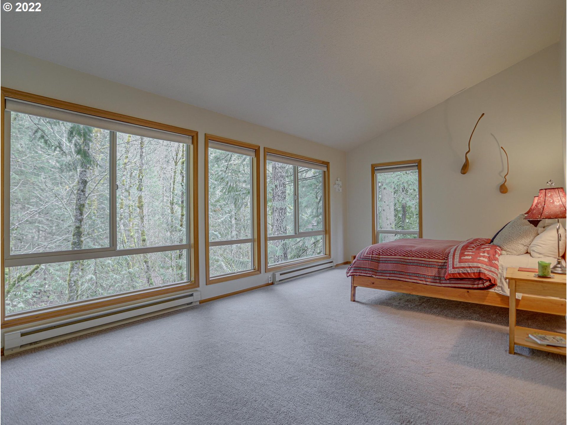 73000 East Village Loop Road Rhododendron, OR 97049 - Photo 23 of 32 a spacious bedroom with a large bed and large windows