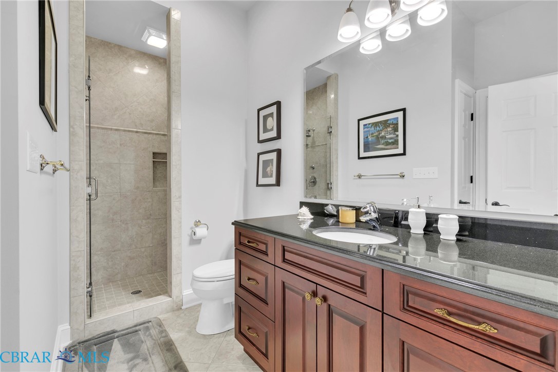 2106 Clarketown Road Heathsville, VA 22473 - Photo 26 of 56 a bathroom with a granite countertop sink a toilet a mirror and shower