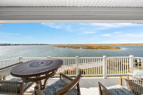 a view of a roof deck with chair and wooden floor