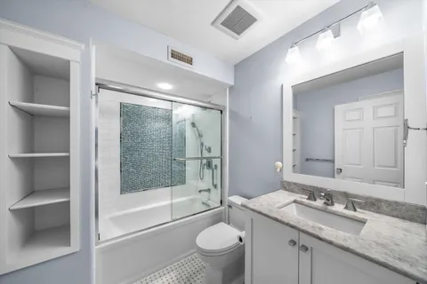 a bathroom with a granite countertop sink toilet and shower