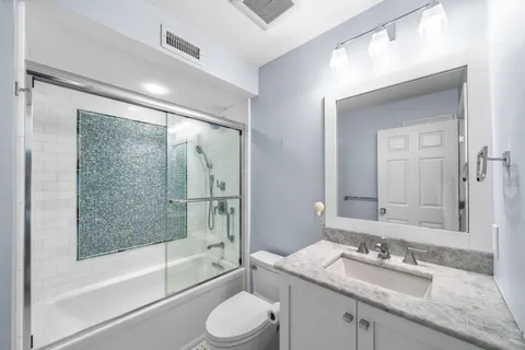 a bathroom with a glass shower door and a bathtub