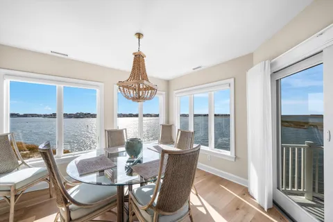 a dining room with furniture a chandelier and wooden floor