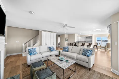 a living room with furniture and a view of kitchen