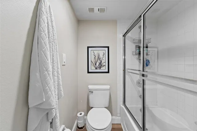 a white toilet sitting next to a shower curtain