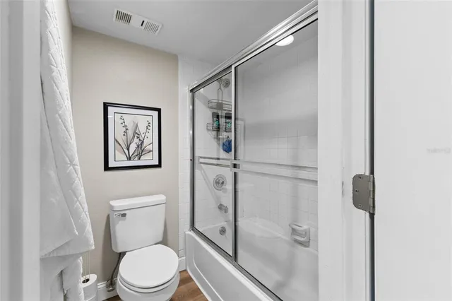 a white toilet sitting next to a shower