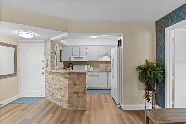 a kitchen with kitchen island white cabinets and wooden floor