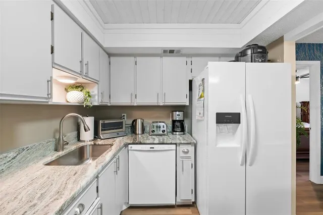 a kitchen with stainless steel appliances granite countertop a sink a refrigerator a stove a microwave and cabinets