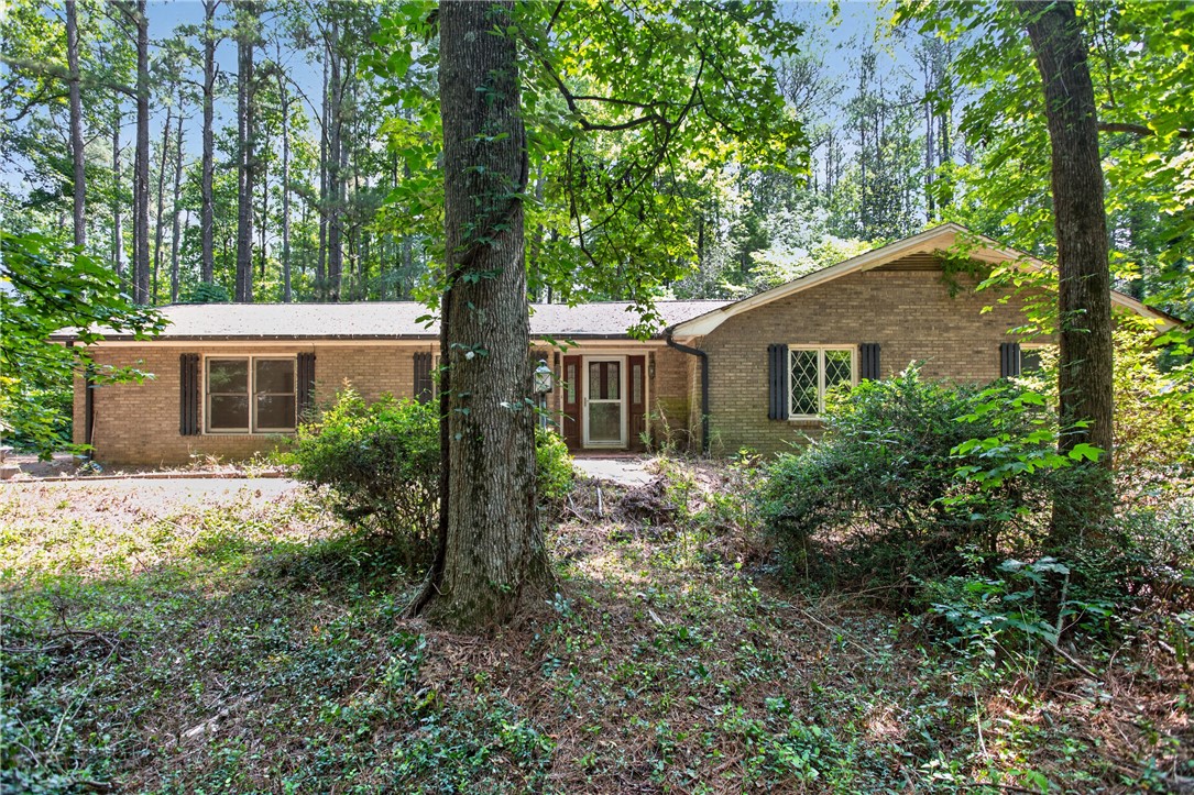 123 Robin Road Westminster, SC 29693 - Photo 2 of 50 Brick facade home nestled amidst a wooded landscape.