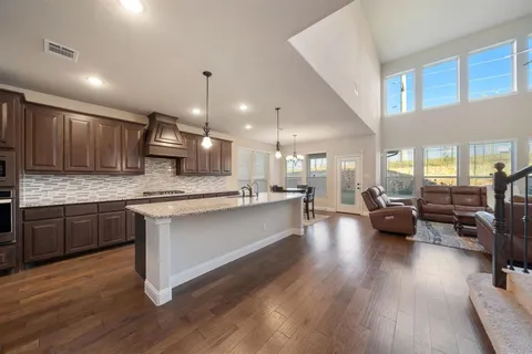 a kitchen with stainless steel appliances granite countertop wooden floors granite counter tops and white cabinets